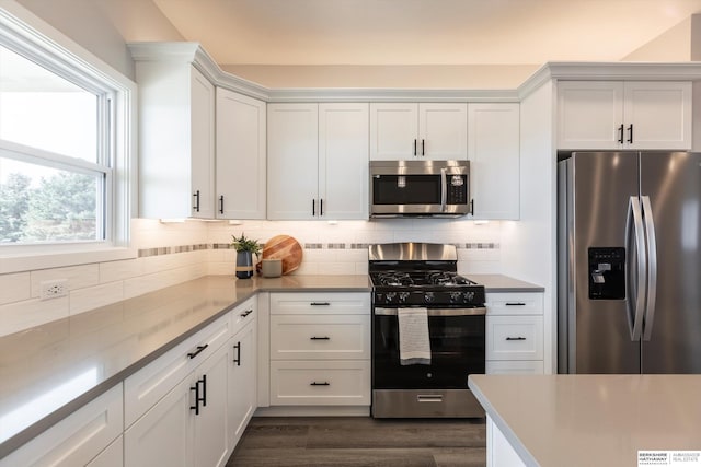 kitchen featuring tasteful backsplash, dark wood-style floors, appliances with stainless steel finishes, light countertops, and white cabinetry