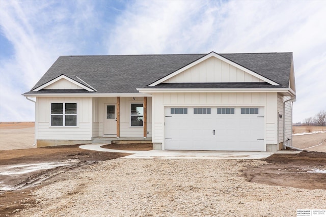 view of front of home with a shingled roof, driveway, board and batten siding, and an attached garage