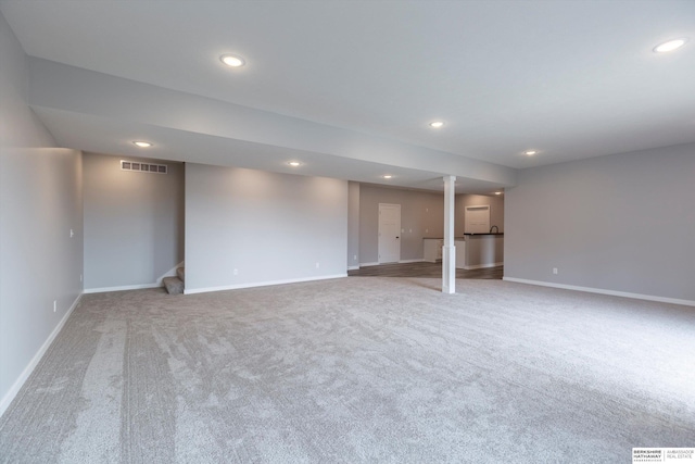 finished below grade area featuring recessed lighting, visible vents, baseboards, and stairs