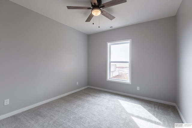 carpeted empty room featuring a ceiling fan, visible vents, and baseboards