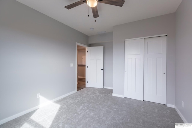 unfurnished bedroom featuring ceiling fan, a closet, carpet, and baseboards