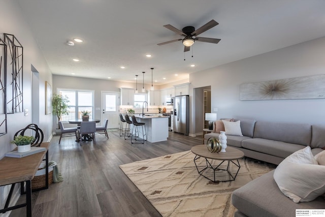 living room featuring dark wood-style floors, baseboards, a ceiling fan, and recessed lighting