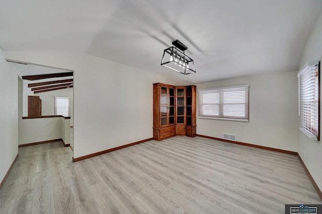 unfurnished dining area featuring light wood-type flooring, vaulted ceiling, and plenty of natural light