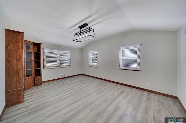 interior space with light wood-type flooring and vaulted ceiling