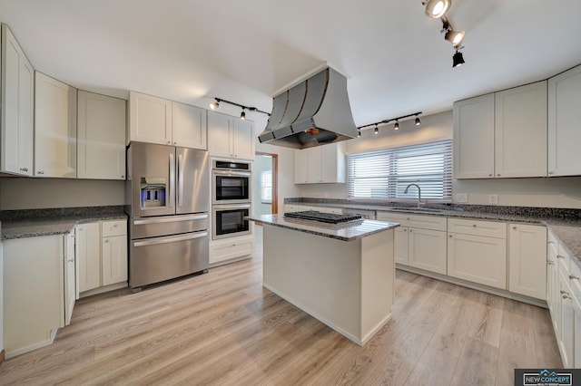 kitchen with sink, stainless steel appliances, white cabinets, and island exhaust hood