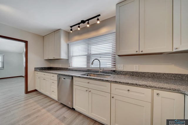 kitchen with dishwasher, dark stone counters, light hardwood / wood-style floors, sink, and white cabinetry