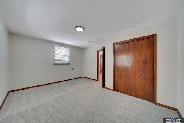 unfurnished bedroom featuring light carpet and a closet