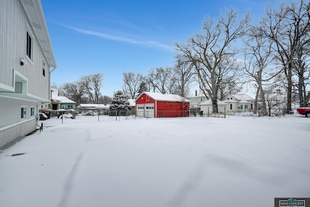 yard covered in snow with a garage and an outdoor structure