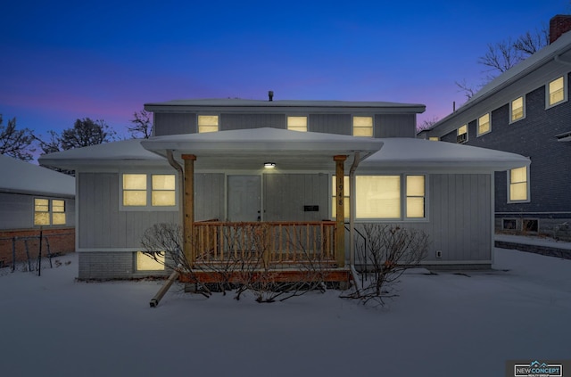 snow covered property featuring a porch