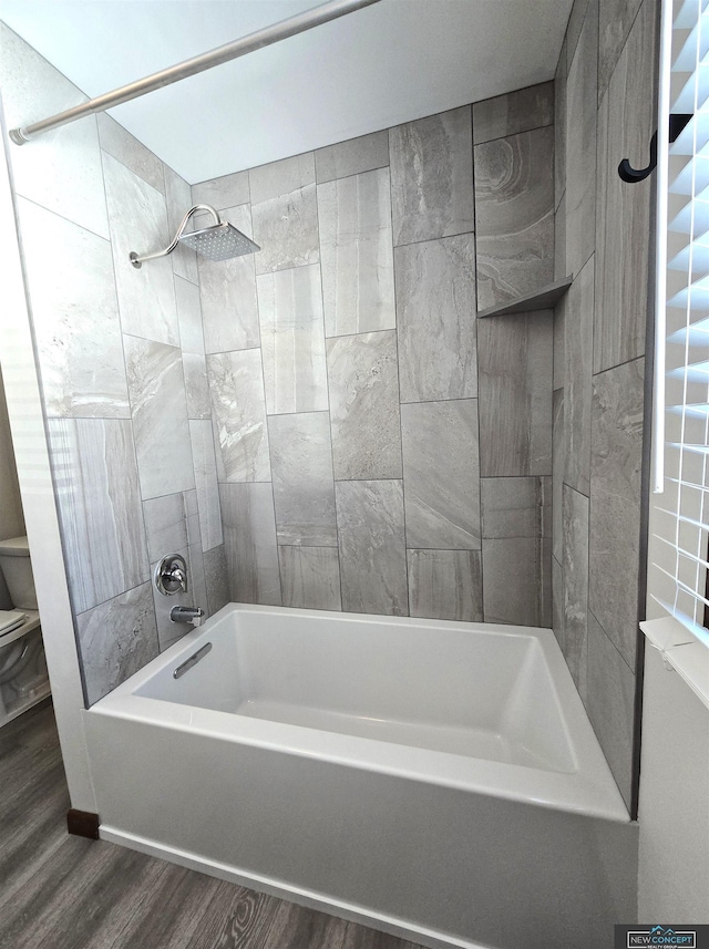 bathroom with tiled shower / bath combo and wood-type flooring