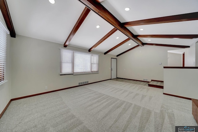 unfurnished living room featuring lofted ceiling with beams and light colored carpet