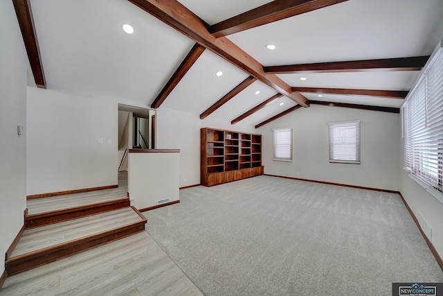 bonus room featuring light carpet and vaulted ceiling with beams