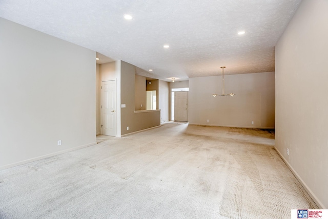 unfurnished room featuring a textured ceiling and light colored carpet