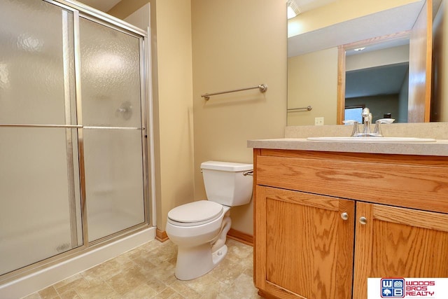 bathroom featuring vanity, toilet, and a shower with door