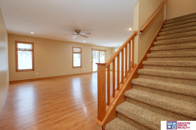 stairs with ceiling fan and hardwood / wood-style floors