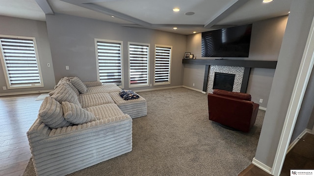 living room featuring beam ceiling and a fireplace