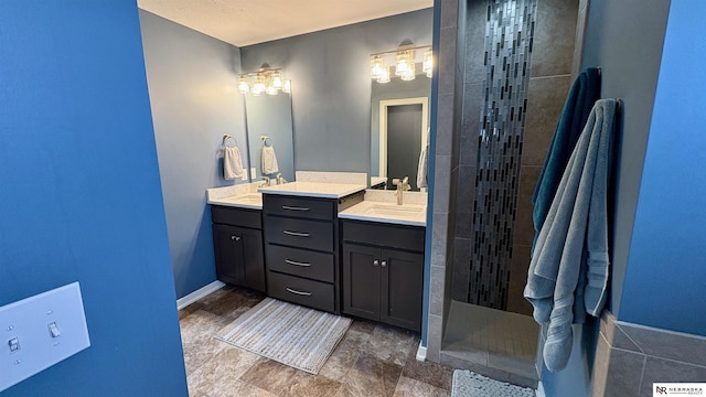 bathroom with a tile shower and vanity