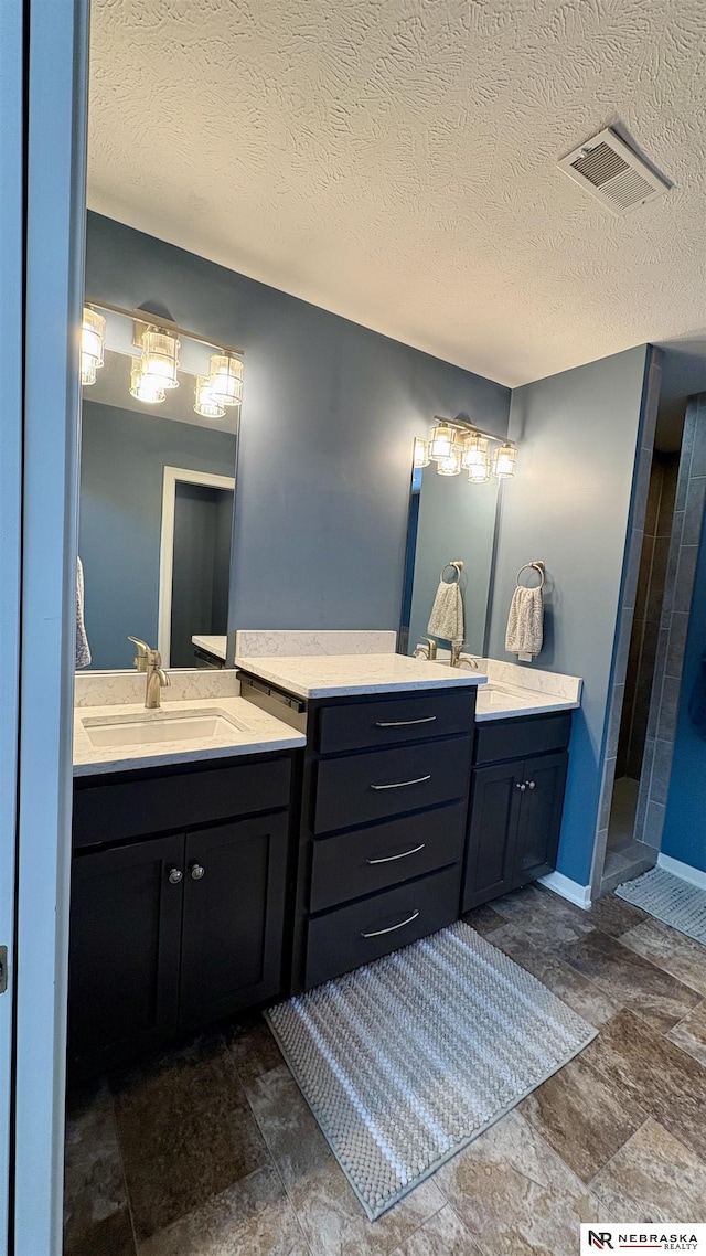 bathroom featuring a textured ceiling and vanity