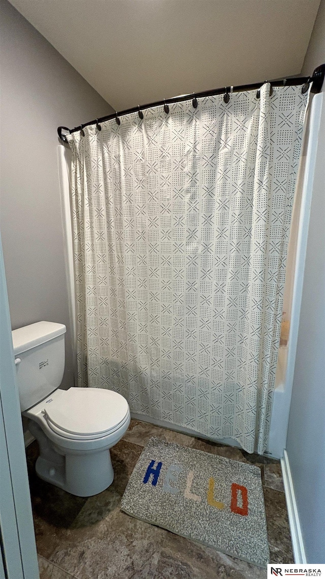 bathroom with toilet and shower / bath combo with shower curtain