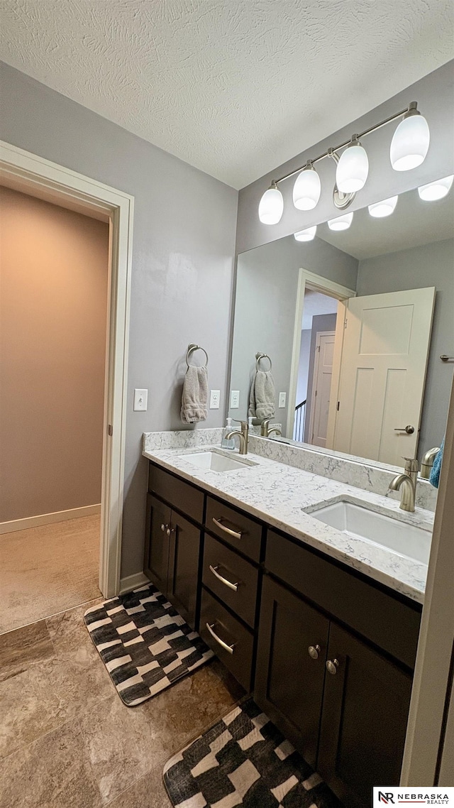 bathroom with a textured ceiling and vanity