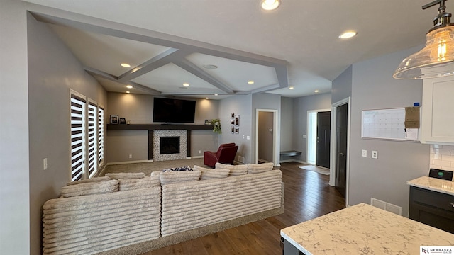 living room featuring coffered ceiling, dark hardwood / wood-style flooring, and beamed ceiling