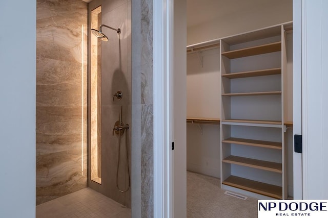 8909 Appaloosa Ln, Lincoln, NE 68520 - bathroom featuring a walk in closet, visible vents, and tiled shower
