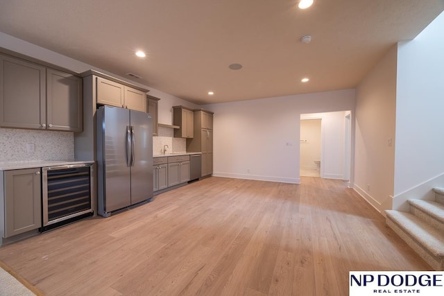 8909 Appaloosa Ln, Lincoln, NE 68520 - kitchen featuring beverage cooler, stainless steel appliances, light countertops, backsplash, and gray cabinetry