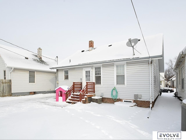 view of snow covered back of property