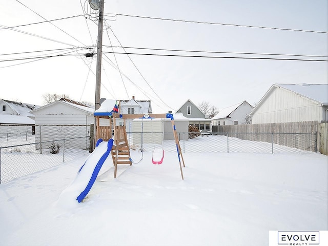 yard layered in snow with a playground