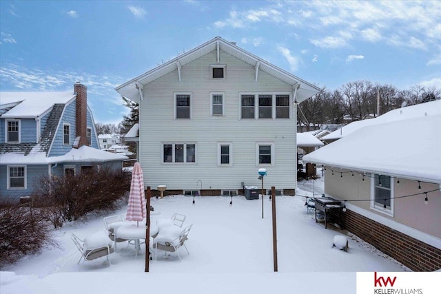 view of snow covered rear of property