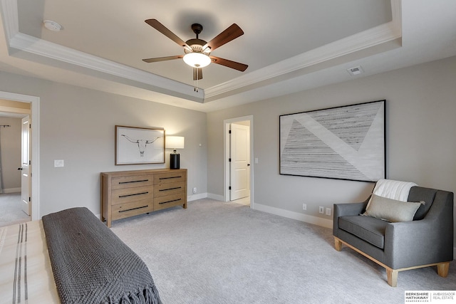 bedroom with a tray ceiling, light carpet, and crown molding