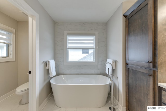 bathroom featuring vanity, a bathtub, and toilet