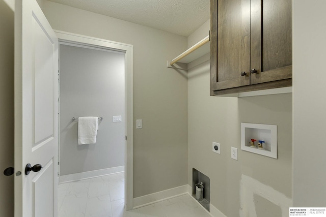 clothes washing area featuring cabinets, a textured ceiling, electric dryer hookup, and hookup for a washing machine