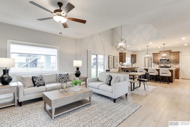 living room with ceiling fan, light hardwood / wood-style floors, and a healthy amount of sunlight