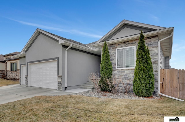 view of front of house featuring stucco siding, an attached garage, fence, stone siding, and driveway