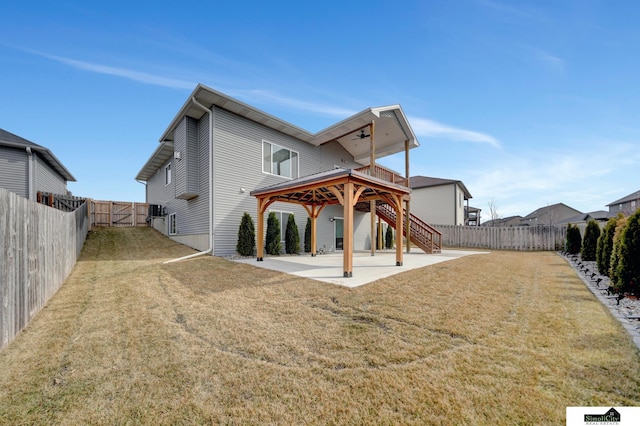 back of house featuring a fenced backyard, stairs, a gate, a yard, and a patio area