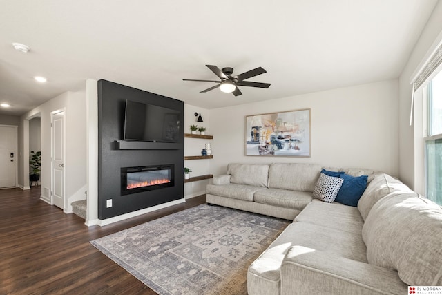 living room with dark wood-type flooring and ceiling fan