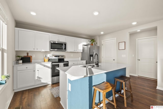 kitchen featuring an island with sink, appliances with stainless steel finishes, sink, and a kitchen bar