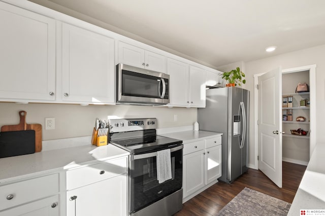 kitchen with dark hardwood / wood-style floors, white cabinets, and stainless steel appliances