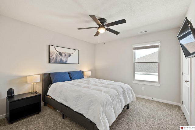 carpeted bedroom featuring a textured ceiling and ceiling fan