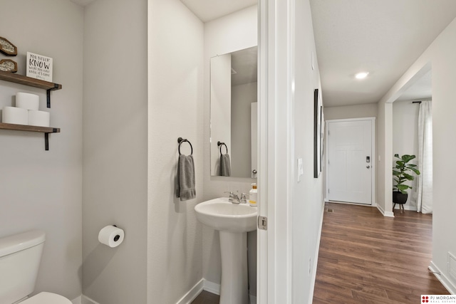 bathroom featuring sink, toilet, and hardwood / wood-style flooring