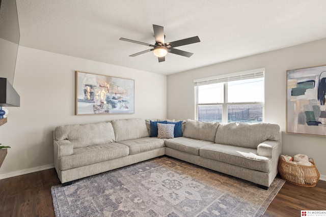 living room featuring ceiling fan and dark hardwood / wood-style flooring