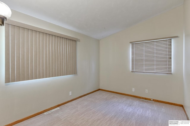 unfurnished room featuring lofted ceiling