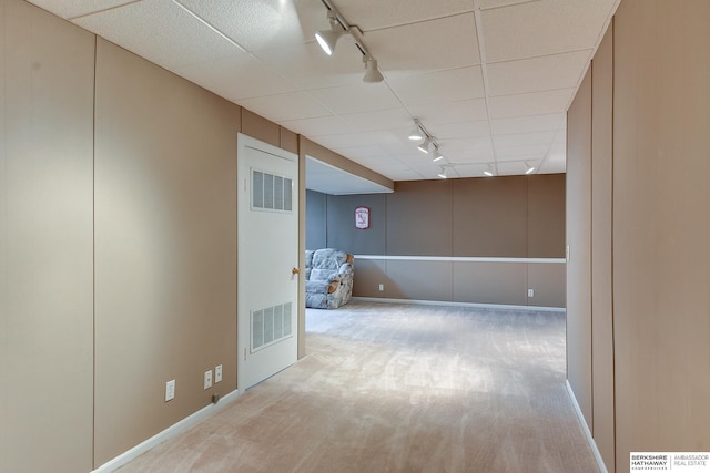 unfurnished room featuring rail lighting and light carpet