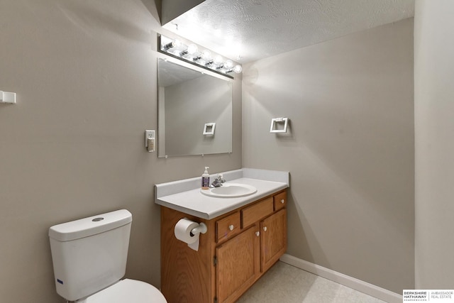 bathroom with a textured ceiling, toilet, and vanity