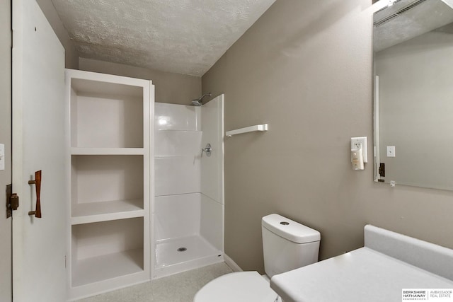 bathroom featuring toilet, a textured ceiling, and walk in shower