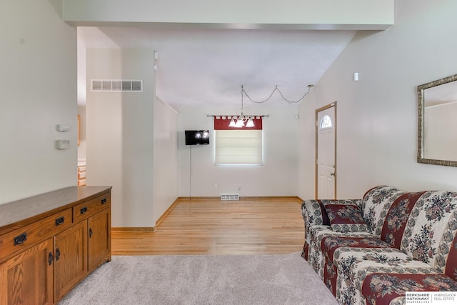 living room featuring light wood-type flooring and lofted ceiling with beams