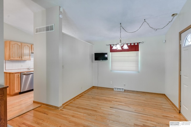 unfurnished dining area with light hardwood / wood-style floors and a chandelier