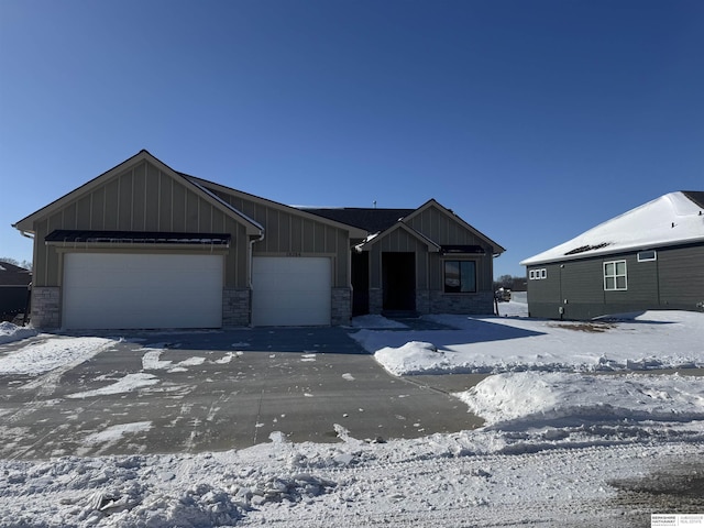 view of front facade with board and batten siding, stone siding, and a garage