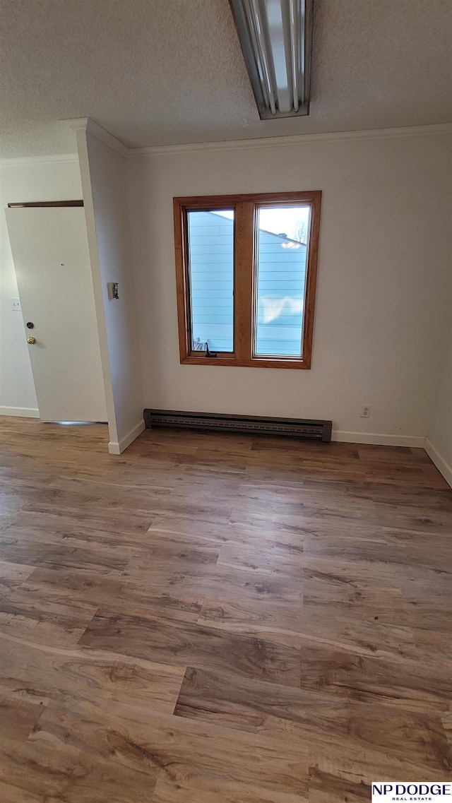 unfurnished room with hardwood / wood-style flooring, a textured ceiling, and ornamental molding